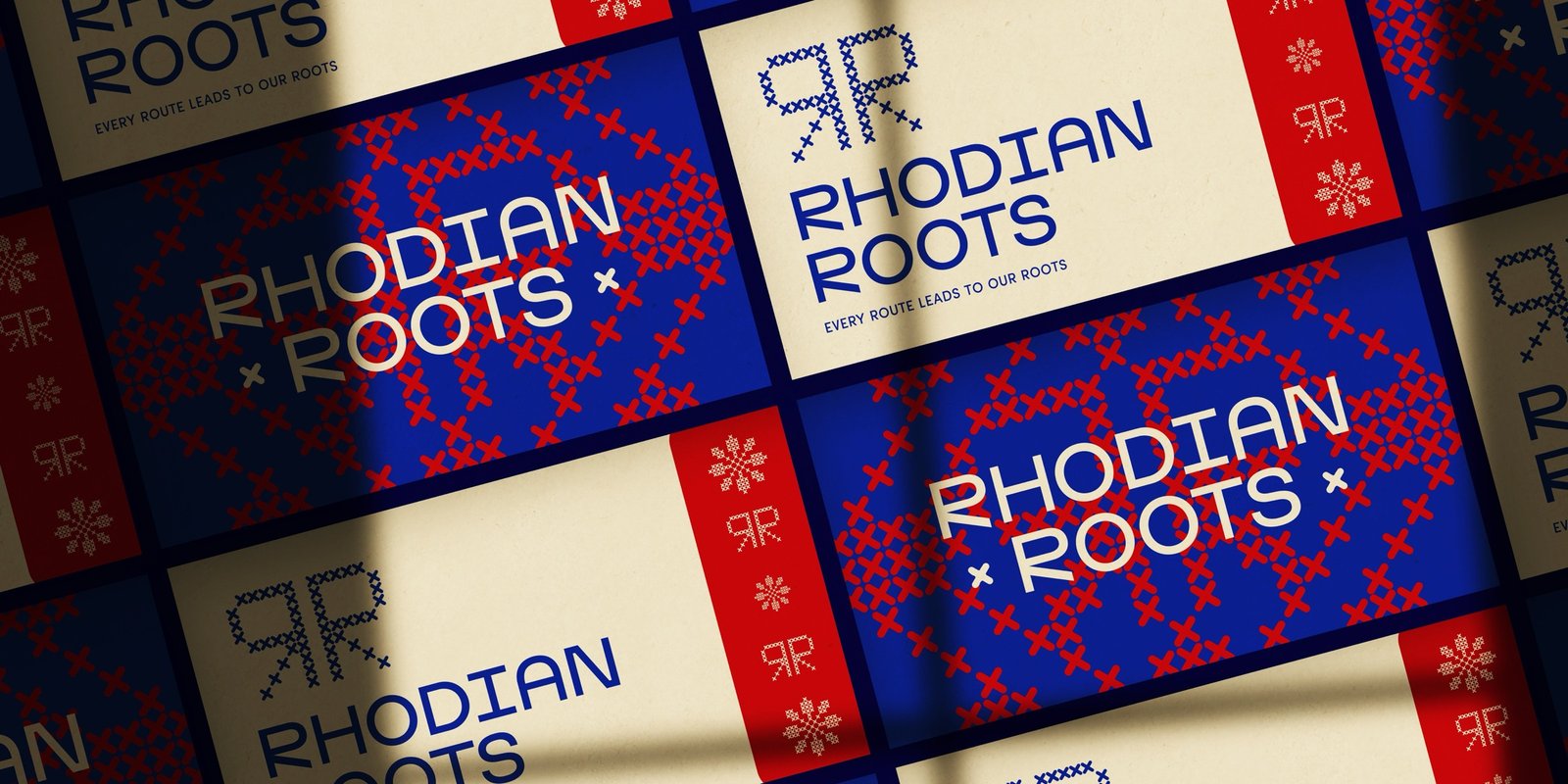 Rhodian Roots business cards in red, blue and sandstone with the cross-stitch pattern